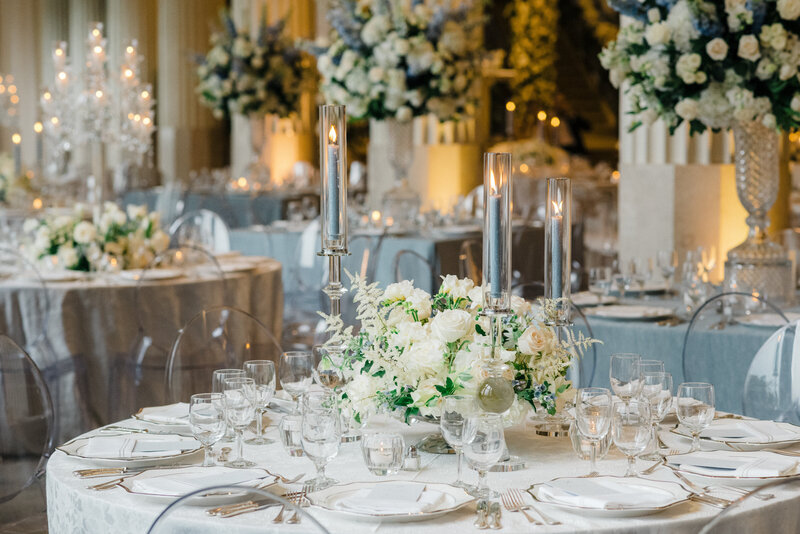 Bride and groom kissing with their reception and guests in the background