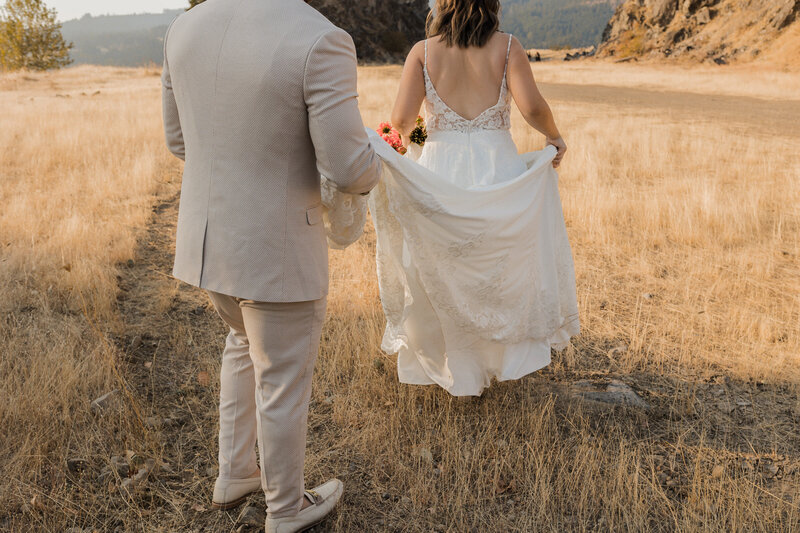 couple laughing holding hands in sand dunes
