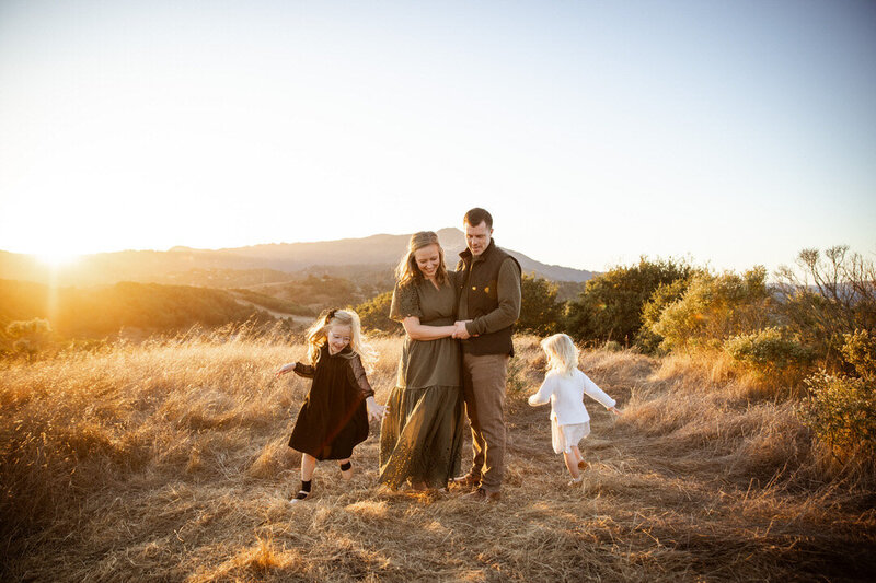 Husband, wife and two daughters playing around the, 