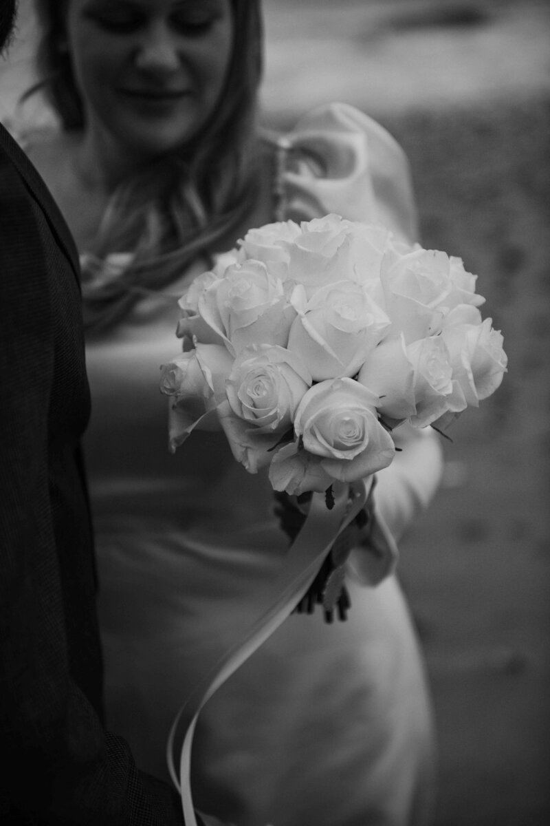 Bride holding her luxurious bouquet of flowers on the beach in Margate with her husband