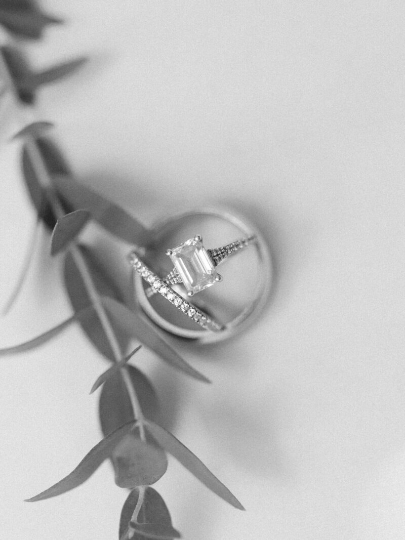 close up shot of emerald engagement ring and wedding rings