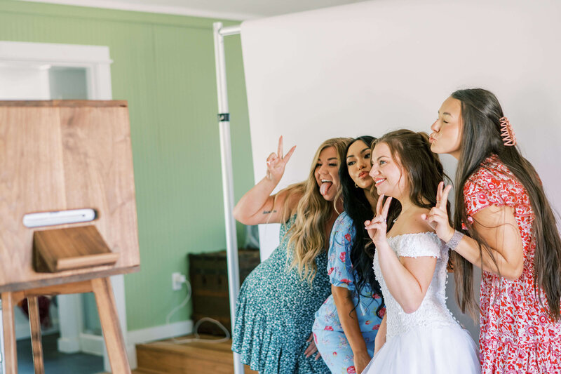 A group of woman makes silly faces at the Birdie Booth, representing a image taken from the Eugene photo booth rental.
