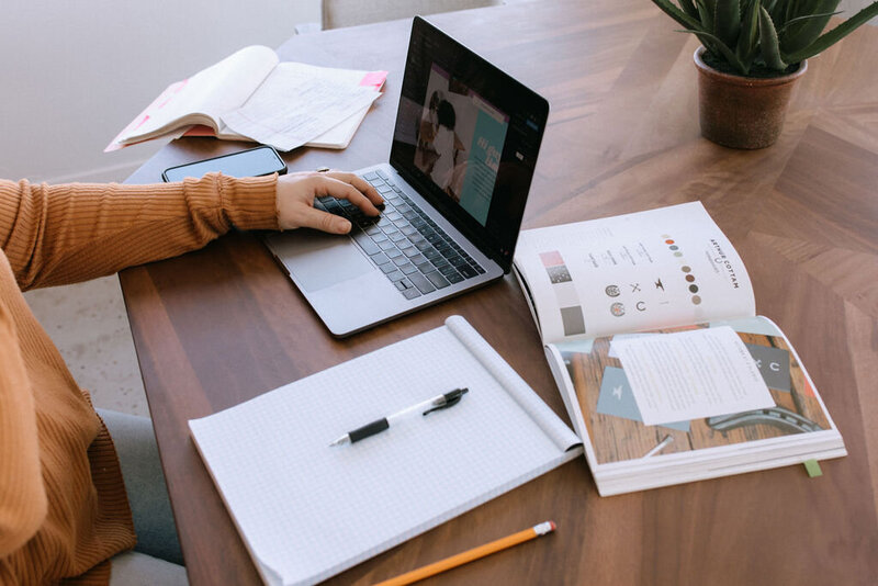 lap top on desk with notepad and book