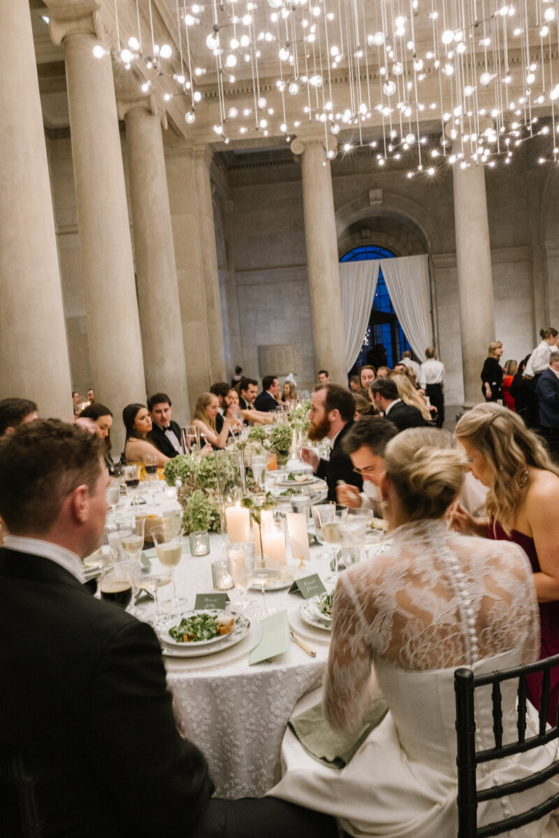 bride and groom enjoying their plated dinner at their baltimore museum of art wedding reception among guests