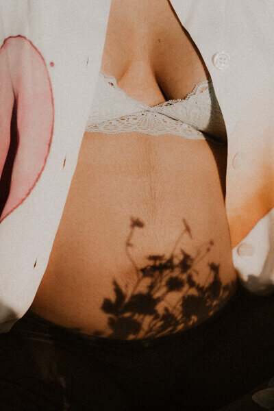 utiliser des fleurs pour dessiner des ombres sur le ventre de femme enceinte