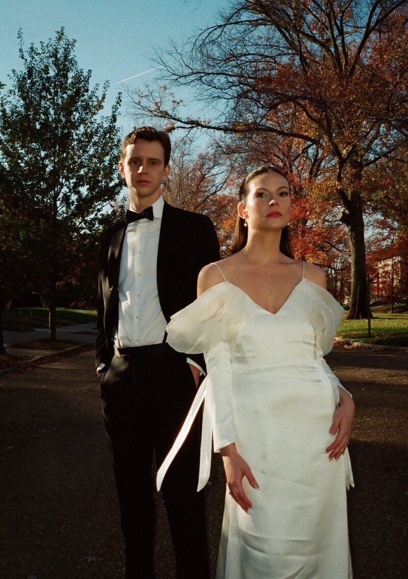 Stylish bride and groom pose with dramatic autumnal lighting