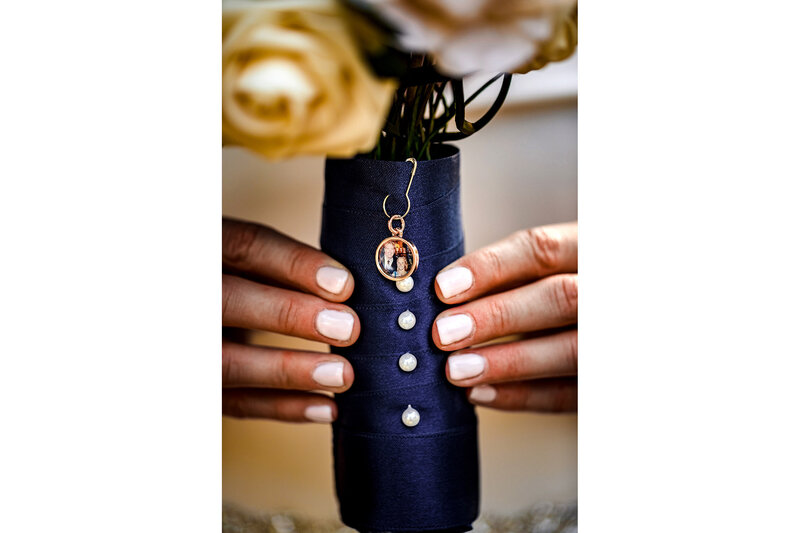 A bride holds a bouquet with a picture of her deceased father during a Meson Sabika wedding.