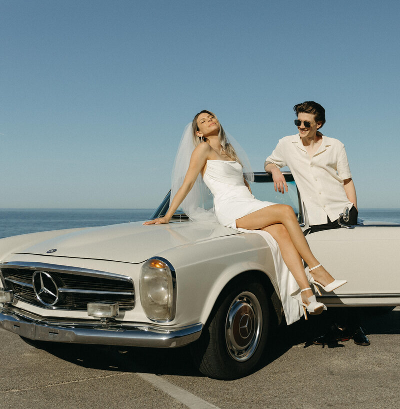 couple in a classic car by the ocean