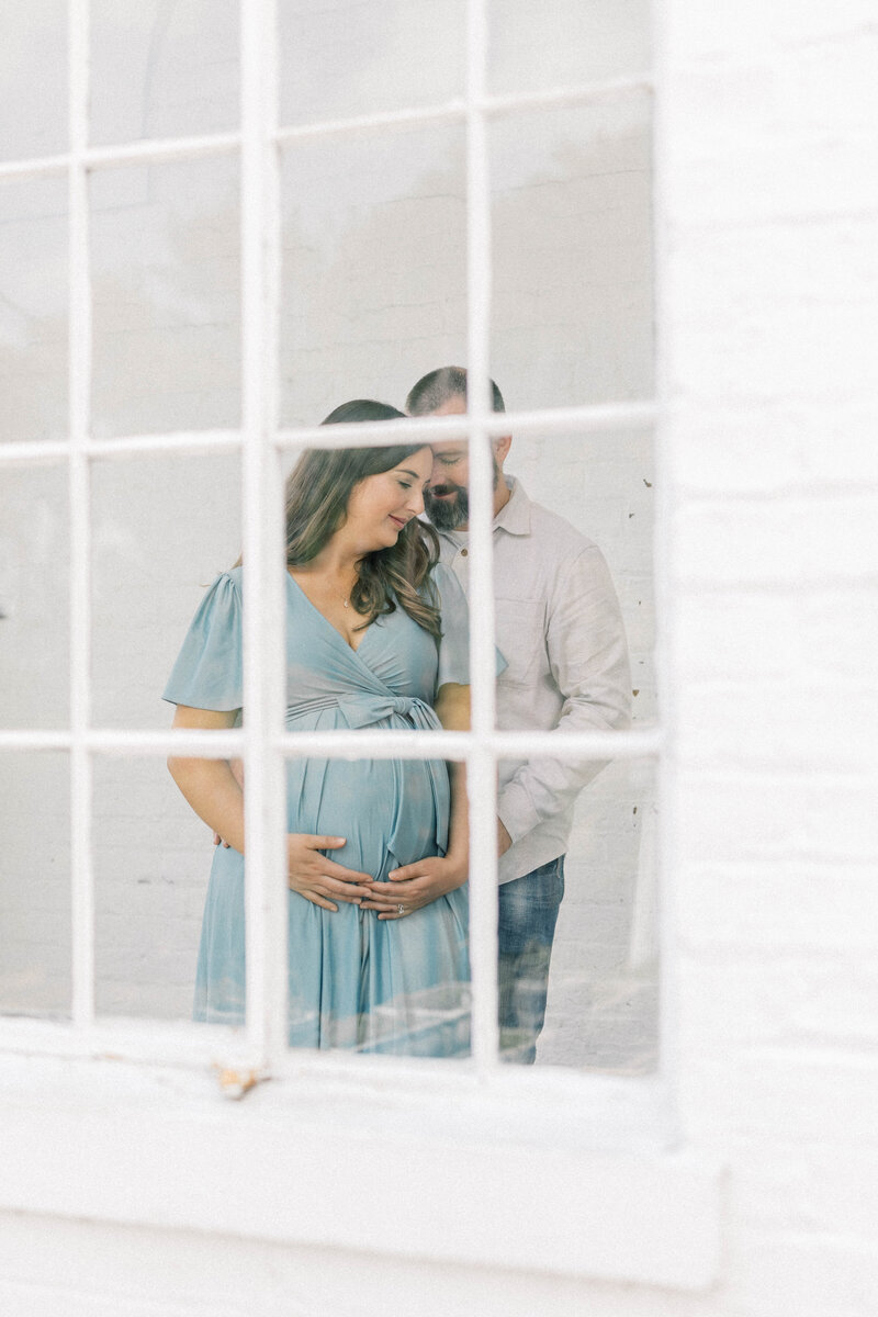 knoxville bleak house maternity session dad holding mom camera looing through window