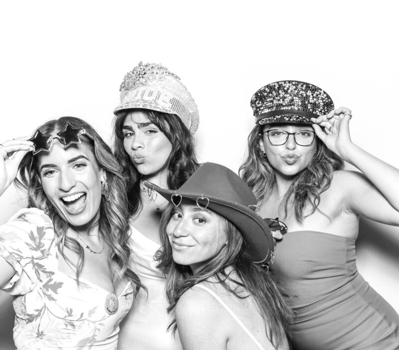 B&W image of large group of friends posing for a Premium photo booth hire and rental for outdoor  weddings, corporate events, brand activations with mad hat photo booth rental