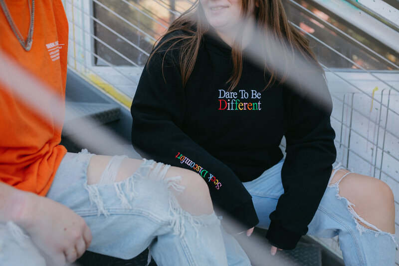 Close up of a sweatshirt that says "Dare to be Different".