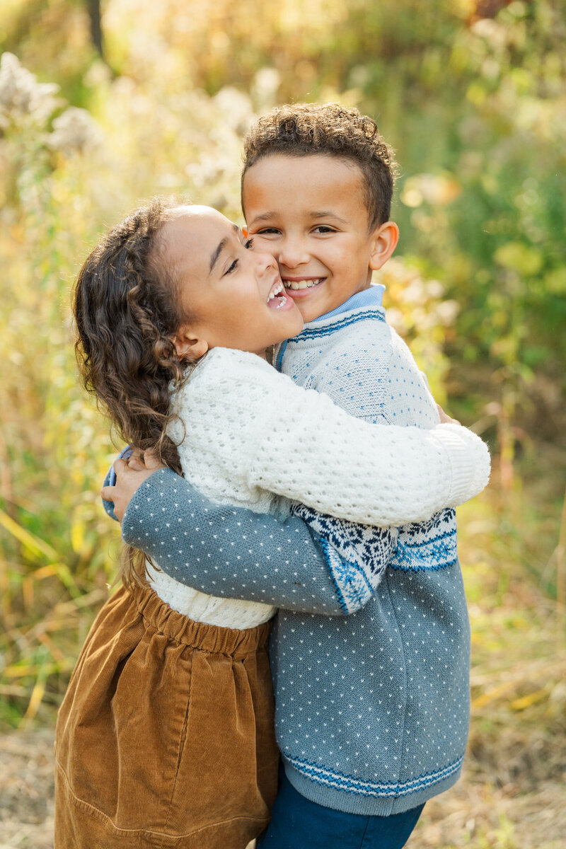 siblings hug during their family session