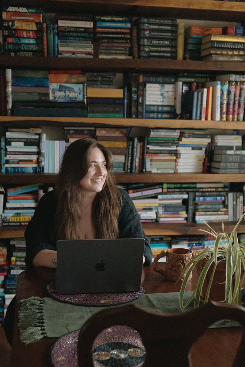 Photo of RVA wedding photographer in front of bookshelves