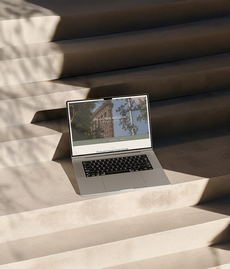 A laptop on steps, overlooking a building, showcasing a Showit website design.