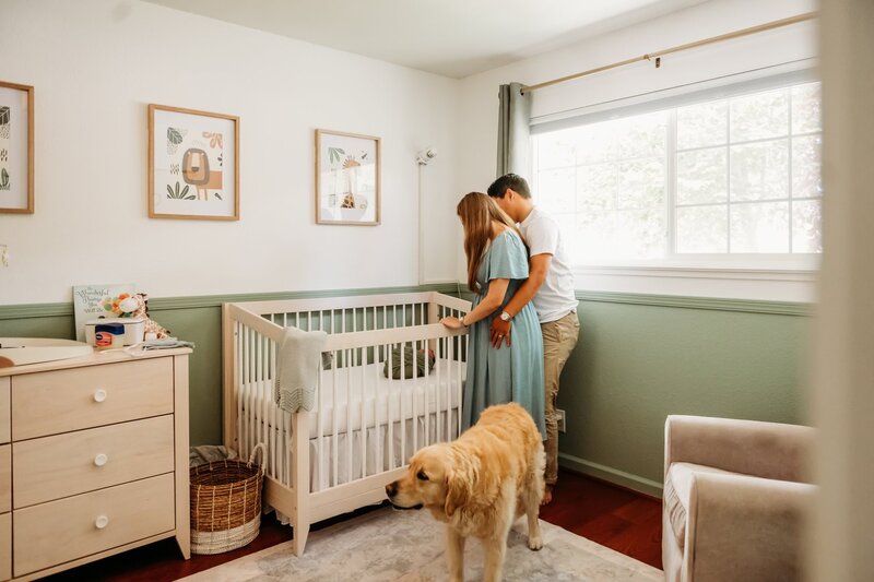 parents looking into their new babys crib in their nursery.