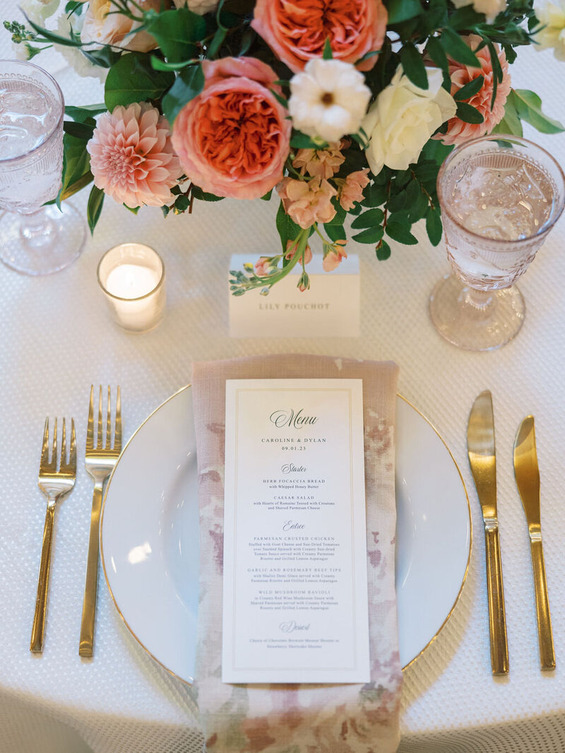 Rustic Tablescape designed by Blue Sapphire Events a Washington DC wedding planner. There are wine goblets, tall candles, and pink and peach flowers.