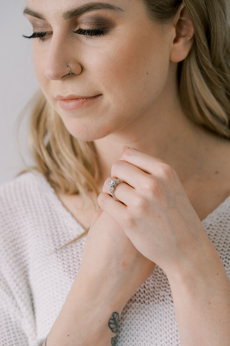 Upclose of woman with hands clasped wearing diamong ring