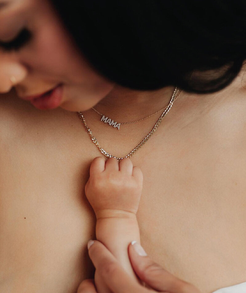 mother with mama necklace with baby reaching for necklace