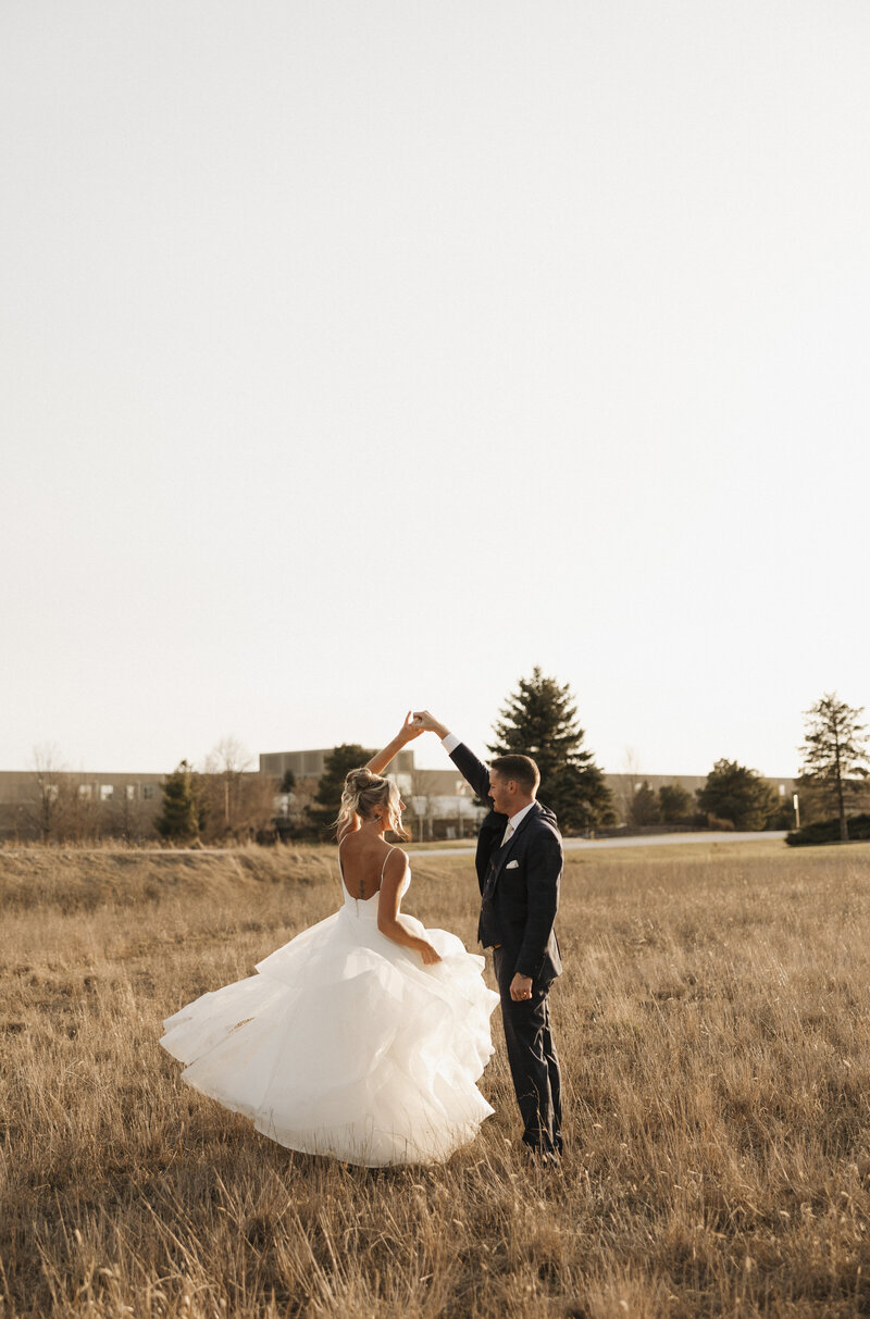 bride spraying perfume on her wrist during wedding day