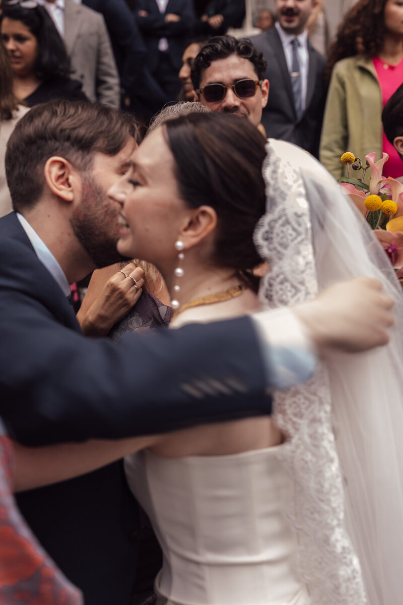 A wedding photographer captures the magical moment of a bride and groom celebrating their wedding ceremony as the bride throws the bouquet in the air