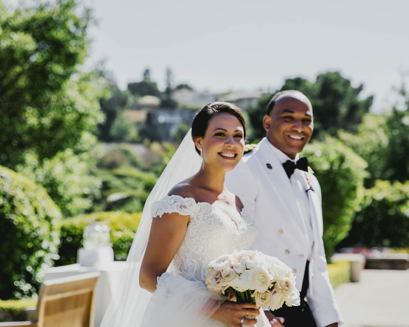 Candid of Bride + Groom walking as she holds her bouquet