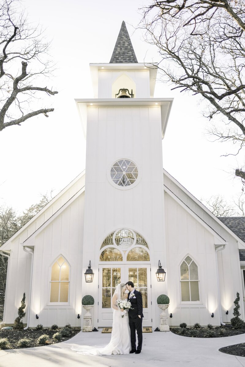 bride and groom standing in front of chapel at the french farmhouse