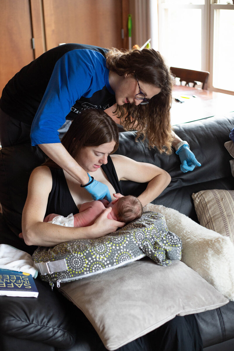 Woman being assisted with breast feeding