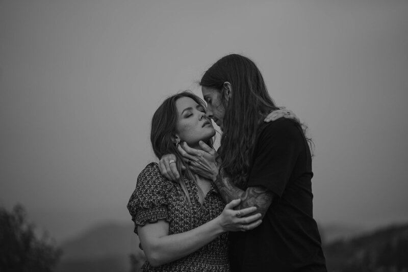 A man holds his wife in the hills of Idaho in black and white.