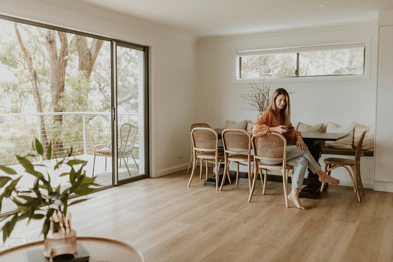 Lady looking at phone sitting at dining table