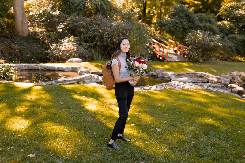 Wedding photographer Sophie Cecile holds a bride's wedding bouquet and stands in to test for lighting.
