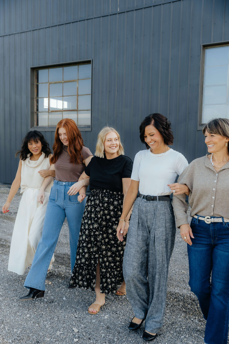 Group of women walking arm in arm, joyful lifestyle photography for modern families and heartfelt Midwest storytelling sessions