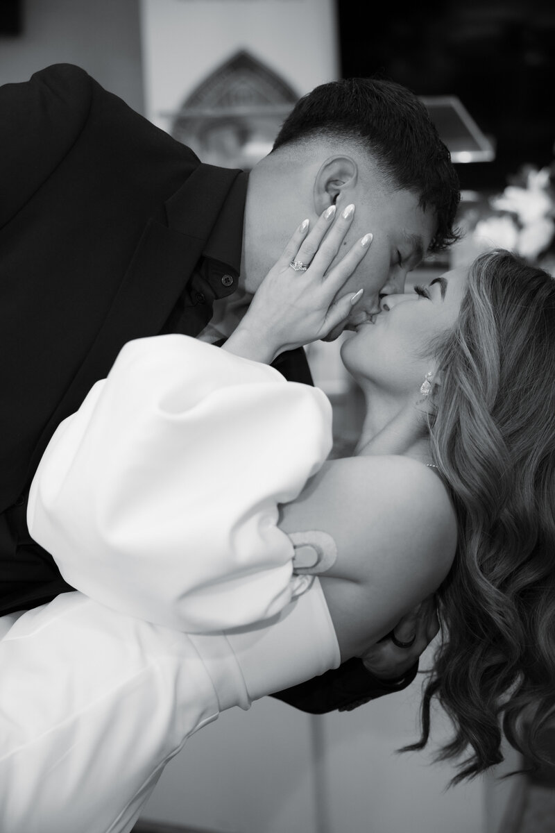 A close-up black-and-white photo of a bride and groom sharing a romantic kiss during their intimate Atlanta elopement.