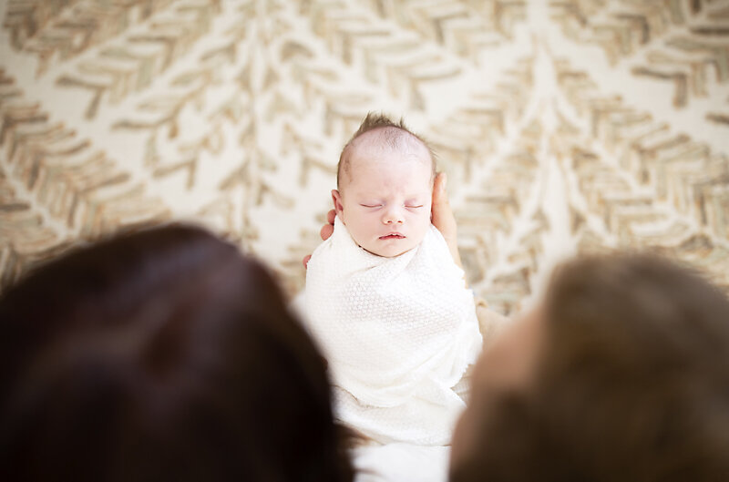 Parents look down on their beautiful newborn baby in Fort Rucker