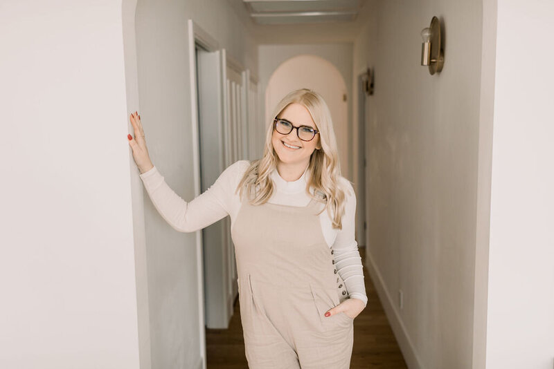 Your EMDR therapist, Megan Zuzevich, poses for the camera with her hand on the wall. She is able to help with trauma, vicarious traumatization, secondary trauma, generalized anxiety disorder and more in the Los Angeles County area with online therapy in California.