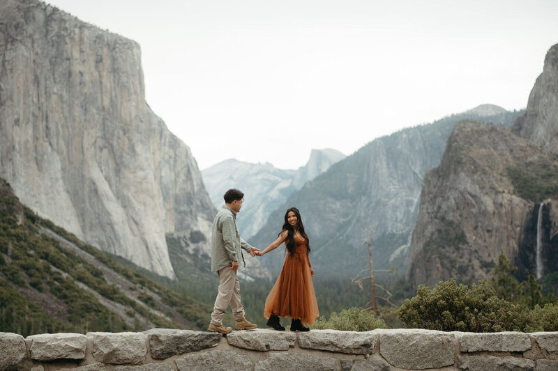Couple walks along the wall at Tunnel view, woman looking back at man