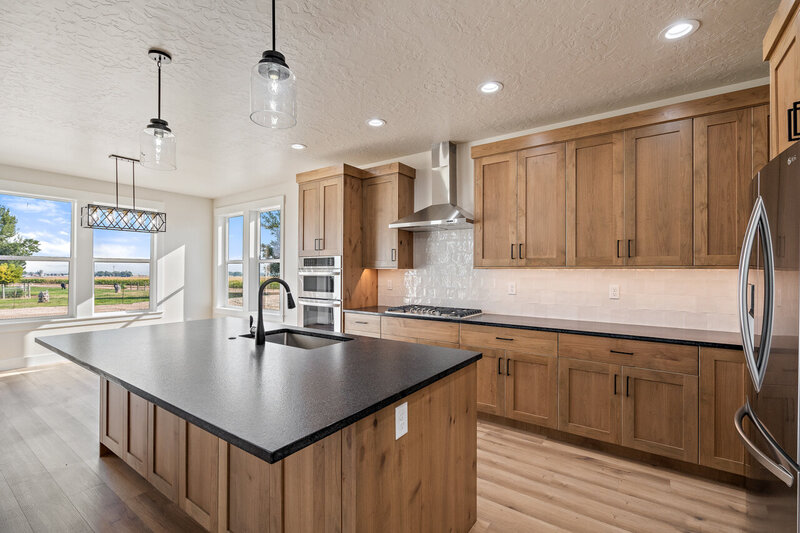 modern kitchen with wooden cabinets and black handles black counter tops