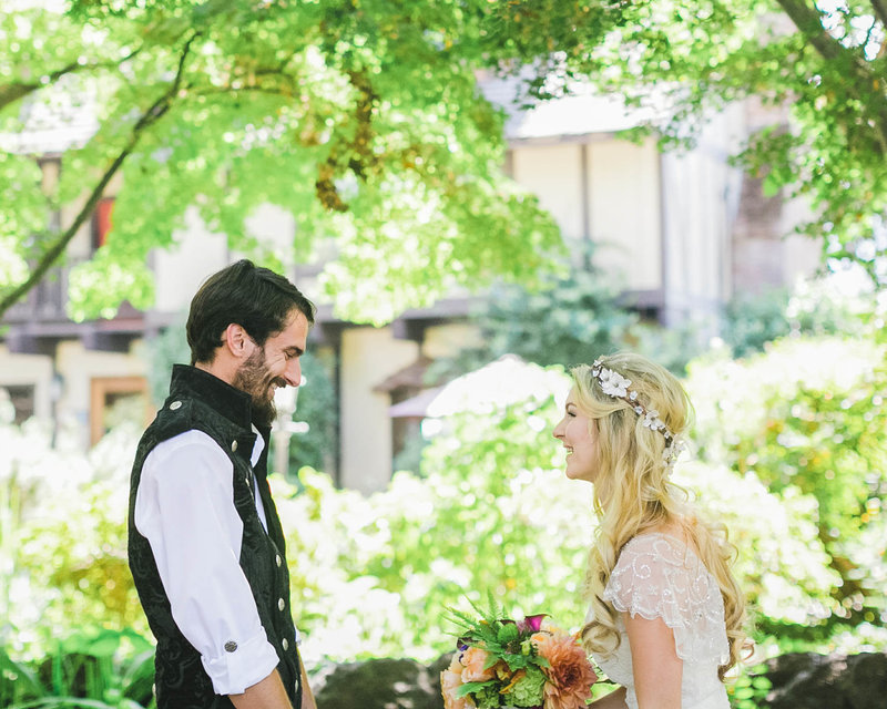 Candid of Bride + Groom facing each other smiling