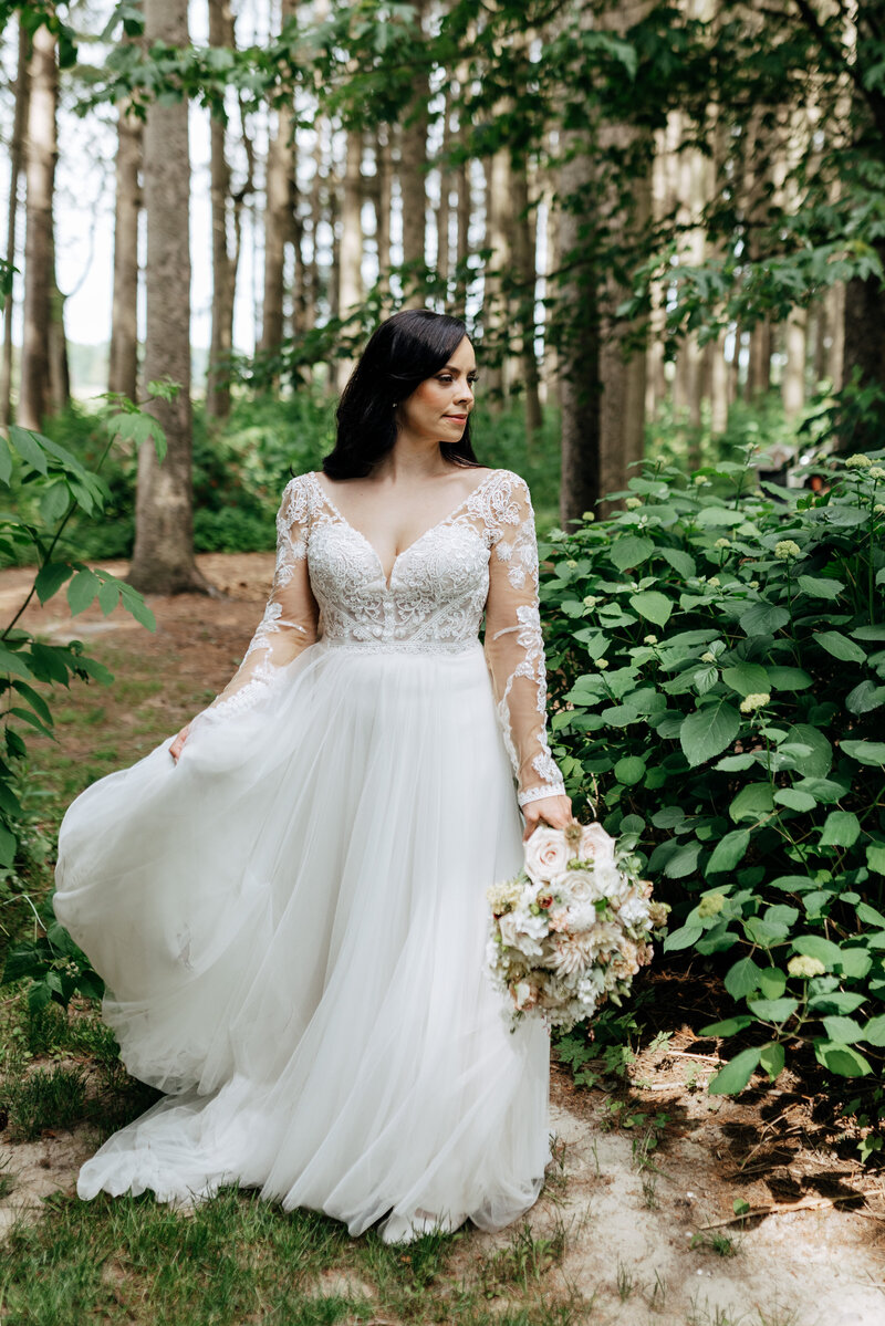 Top London, ON Wedding Photographer and Videographer Ashlee Ellison sits in a white studio