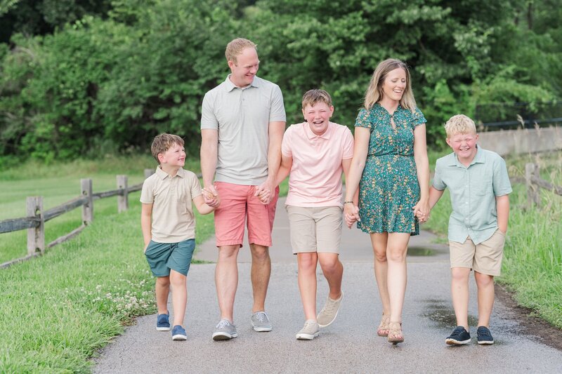 parents walking while holding hands with their 3 boys