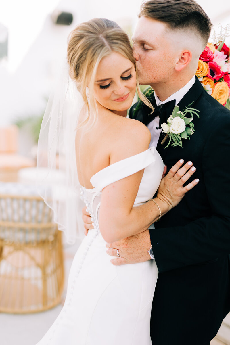 Bride glancing down her shoulder while groom kisses cheek | Winx Photo Tennessee Wedding Photographer