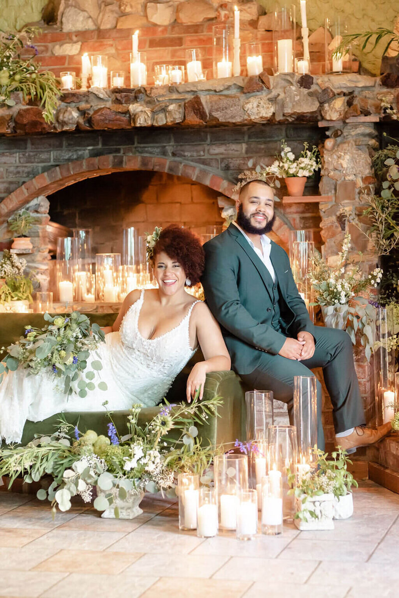 bride and groom pose with florals and candles at wedding