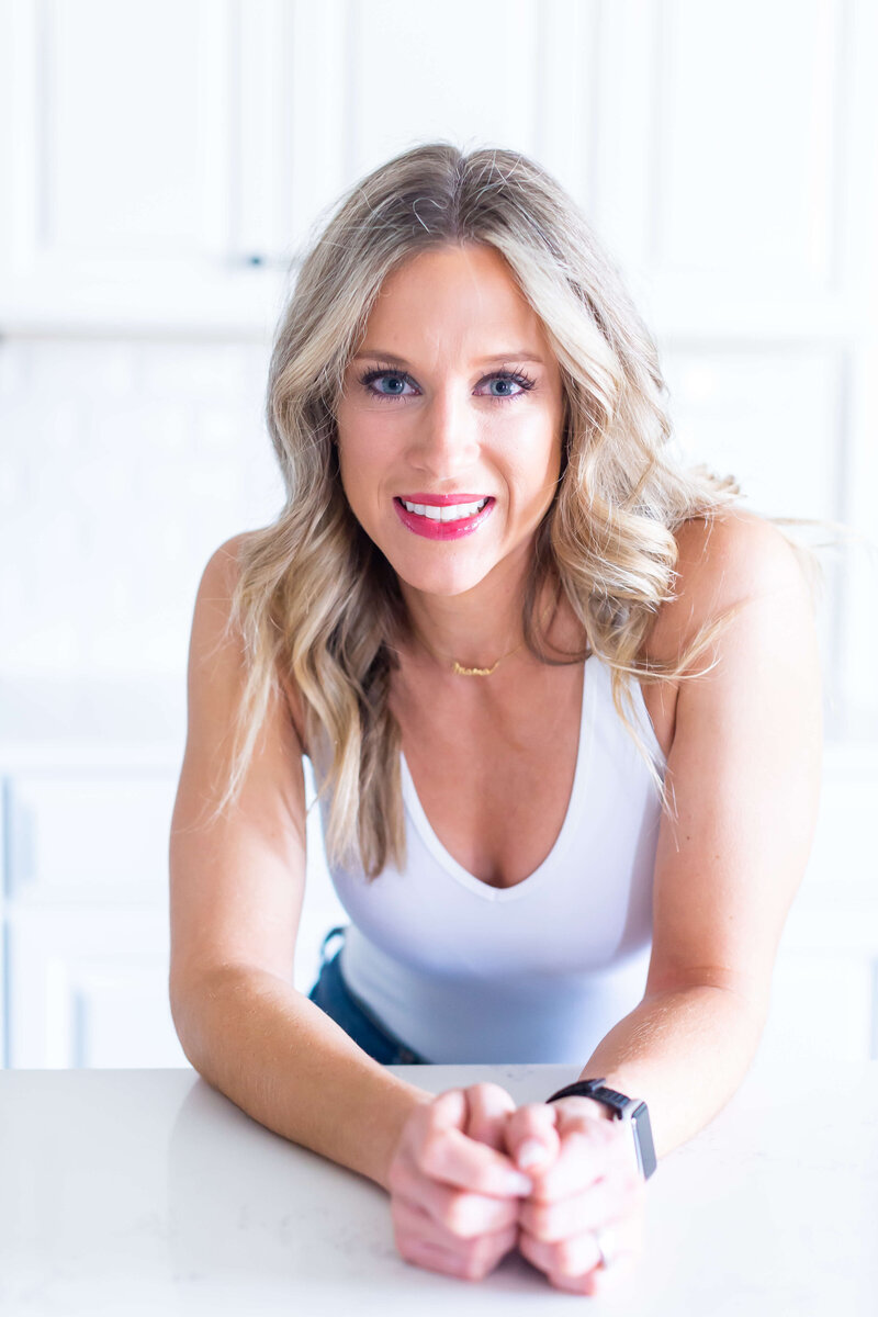 blondewoman wearing purple tank and red lipstick posing for photo shoot