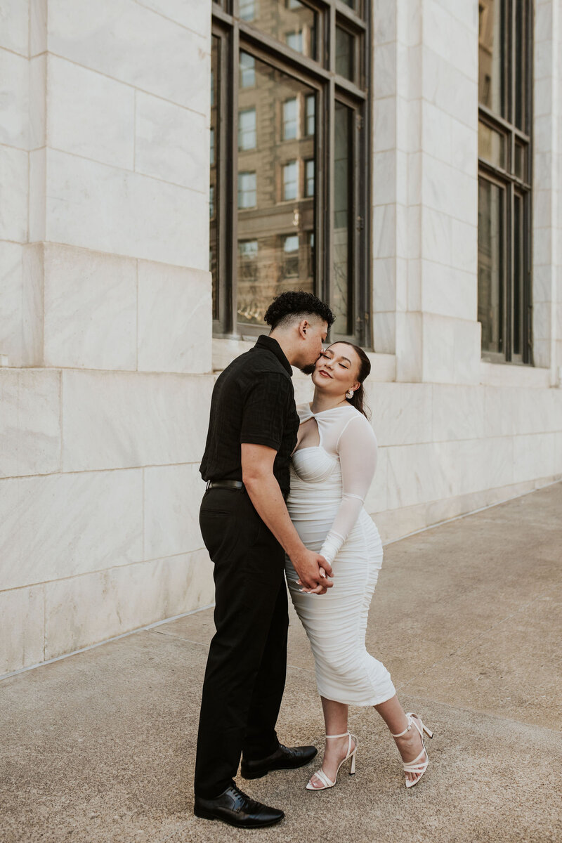 a man kissing his fiances cheek downtown kansas city