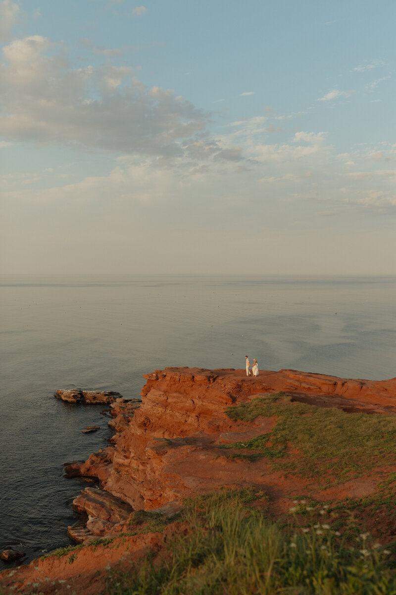 couple embrace on pier for lifestyle session in prince edward island