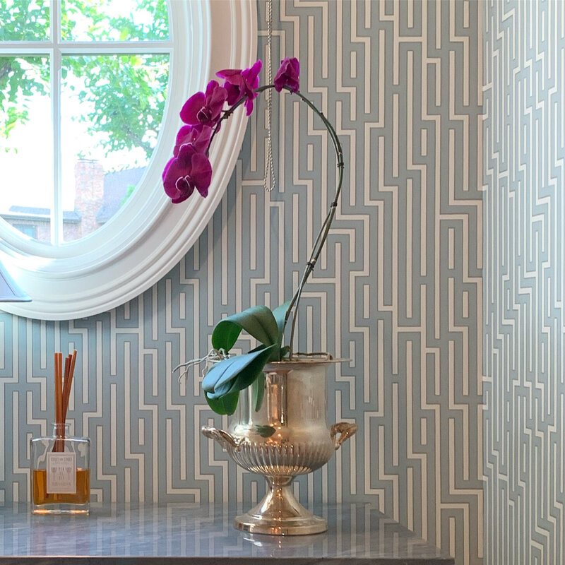 Colorful wallpapered bathroom with green sink