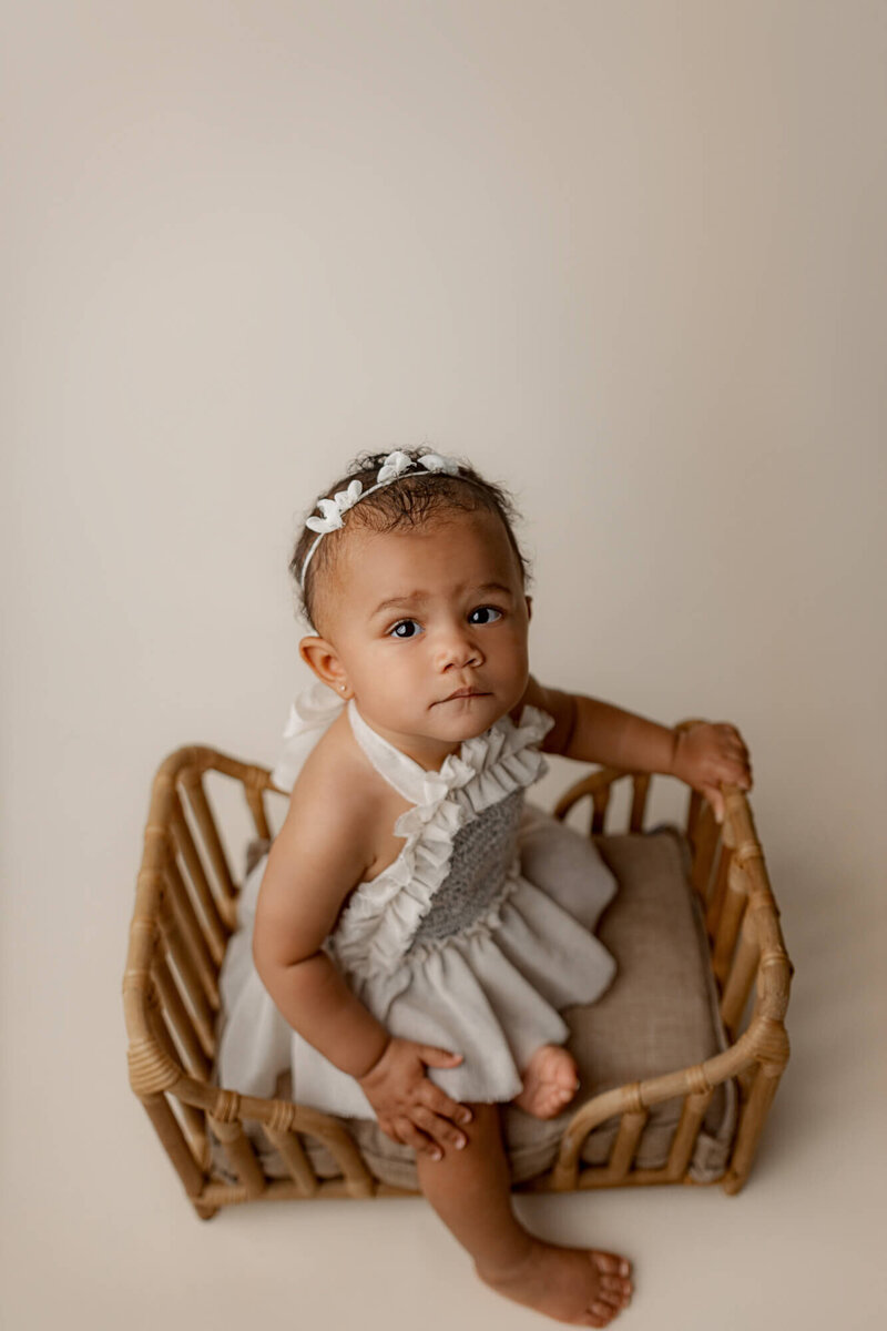 milestone picture of toddler sitting on heart shaped bed