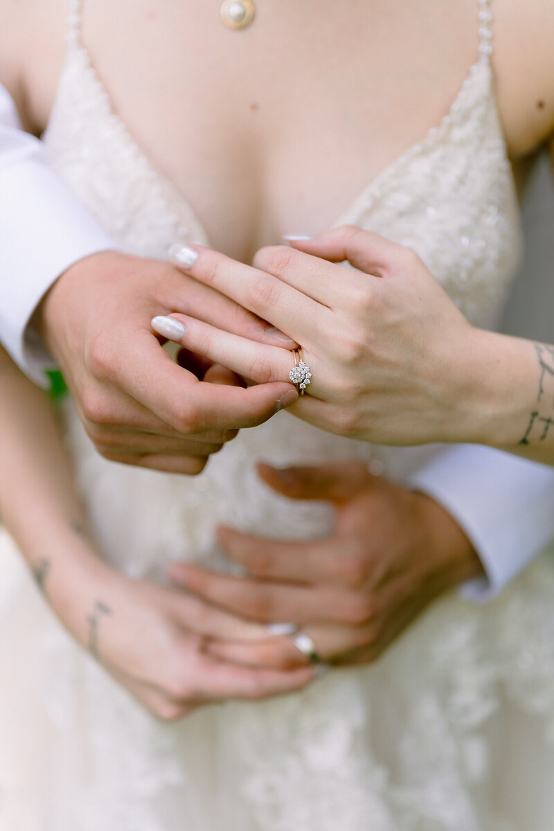 Bride with tattooed arms putting on a wedding ring.