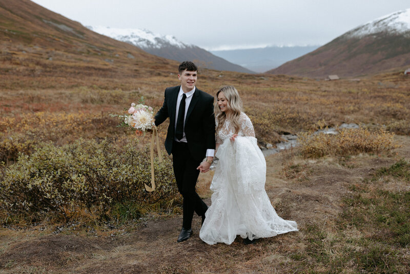 Couple holding hands and looking in opposite directions.