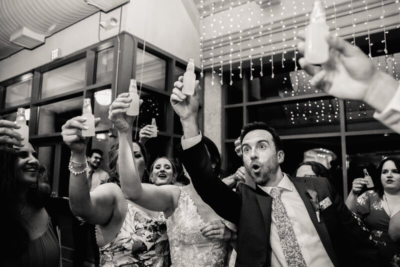wedding guests celebrate with drinks in their hands.