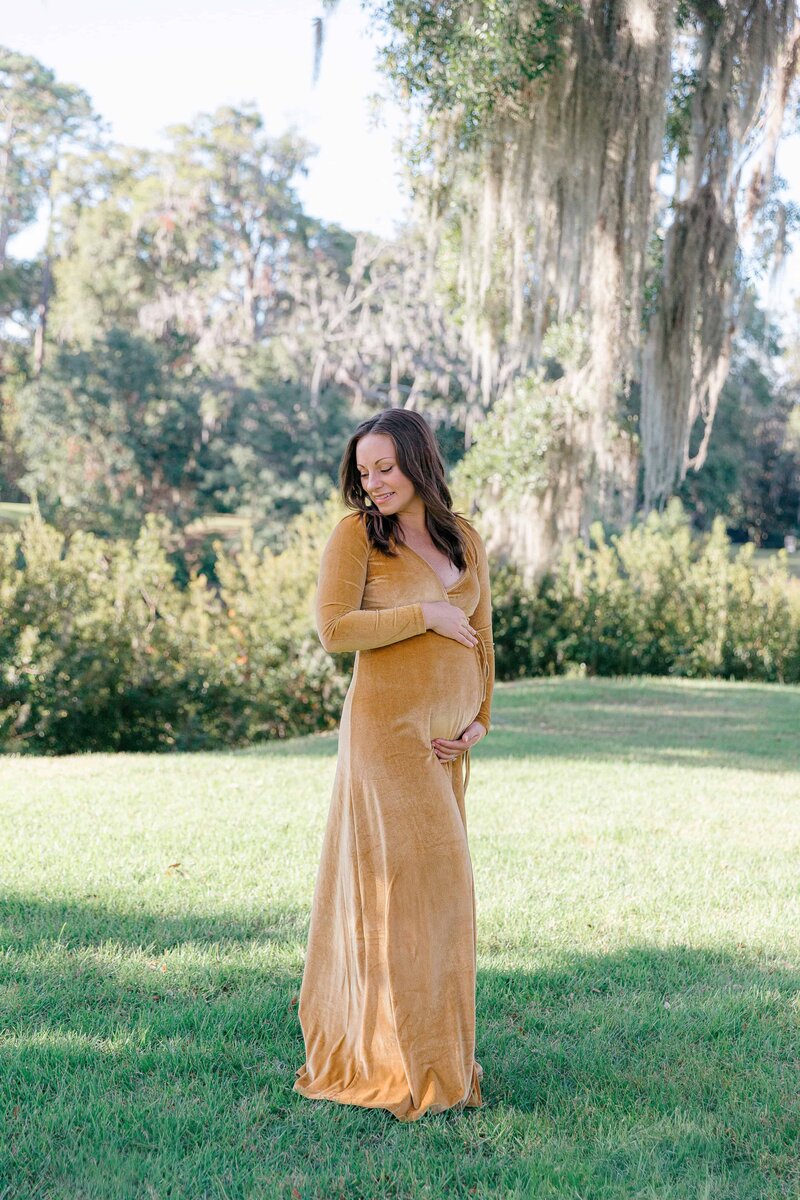 Woman embracing her belly for maternity portrait with Palmetto Bluff Photographer Lamp and Light Photography.
